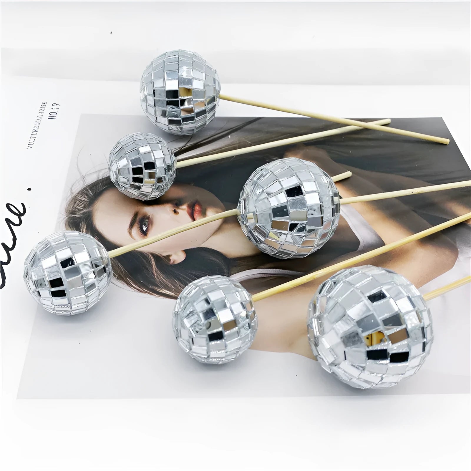 Glass mirror disco ball cake topper on a wooden stick for birthday party cupcakes.