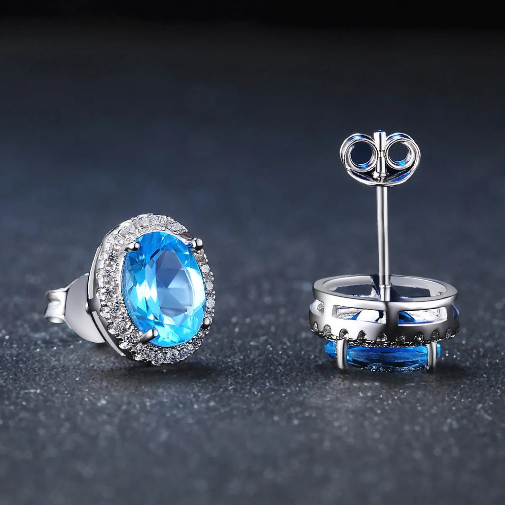 925 sterling silver jewellery set with blue topaz gemstones showing geometric design earrings, ring, pendant, and necklace