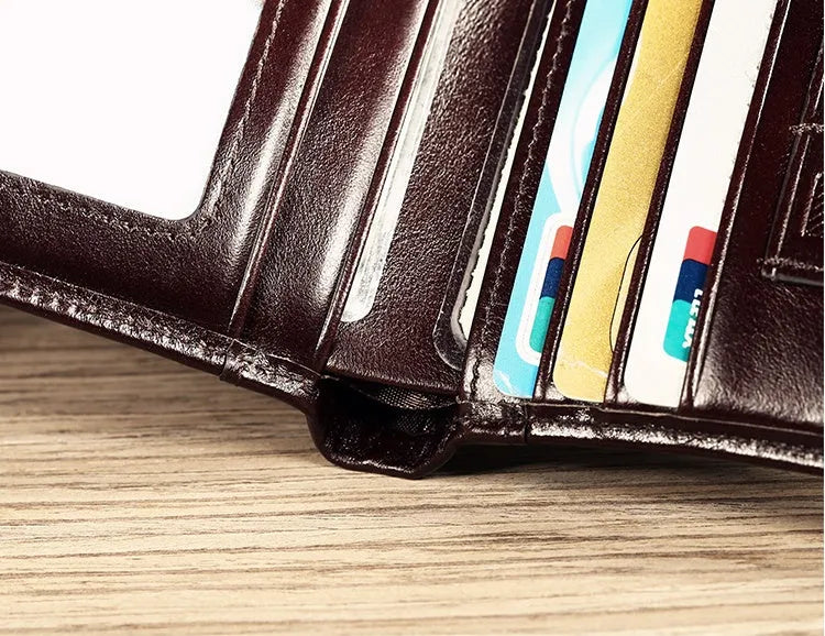 Men's brown leather bifold wallet open to show internal card slots, coin pocket, and photo holder.