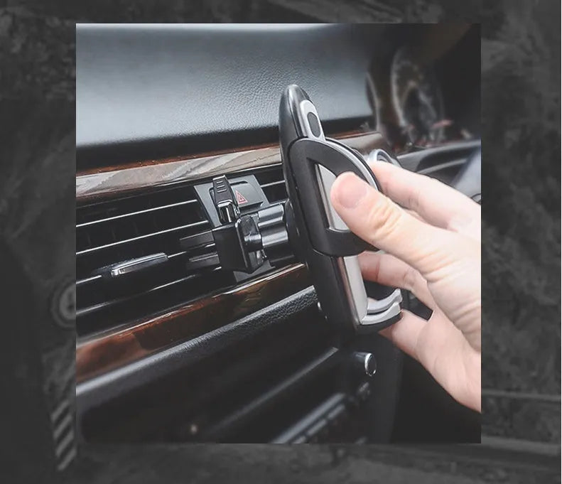 Black car air vent mobile phone holder attached to air conditioning outlet holding smartphone