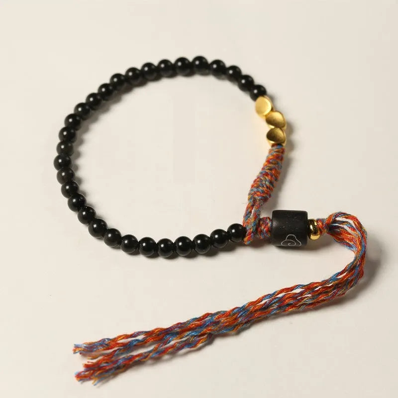 Hand-woven obsidian carrying strap bracelet showing textured surface and dark colour