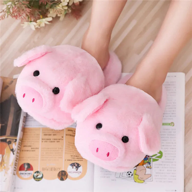 Pink pig-shaped floor slippers with a soft plush fabric exterior.