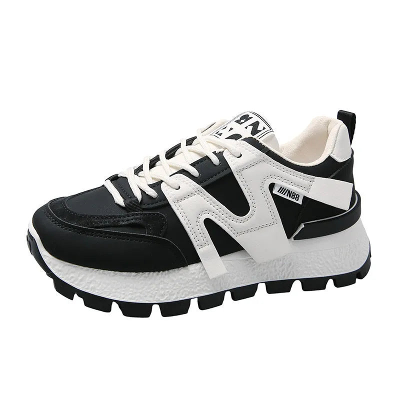 Unisex low-top sneaker in black with round toe, flat heel, and lace-up front on a rubber sole.