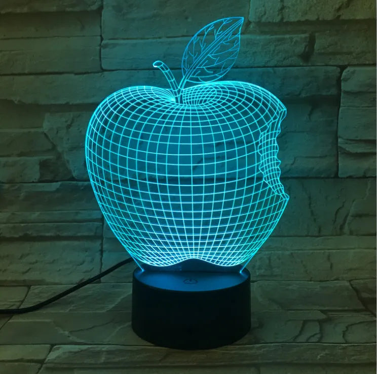 Colourful 3D fruit-shaped LED night light with touch control on a surface.