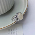 Adjustable copper U-shaped vintage ring with a white chalcedony effect finish.