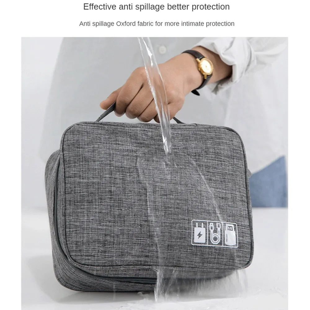 Black waterproof electronics organiser case open, showing mesh pockets, elastic loops, and removable padded dividers inside.