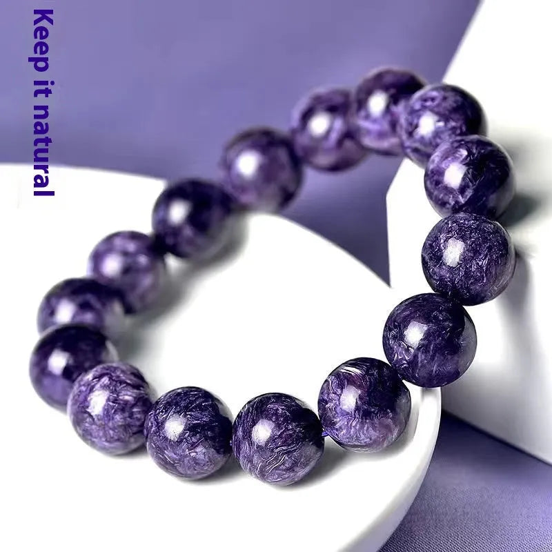 Natural transparent charoite crystal bracelet with platinum elements on a wrist.