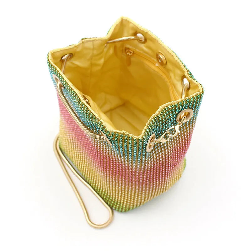 Rainbow rhinestone bucket bag with glittering crystals and a metal chain strap.