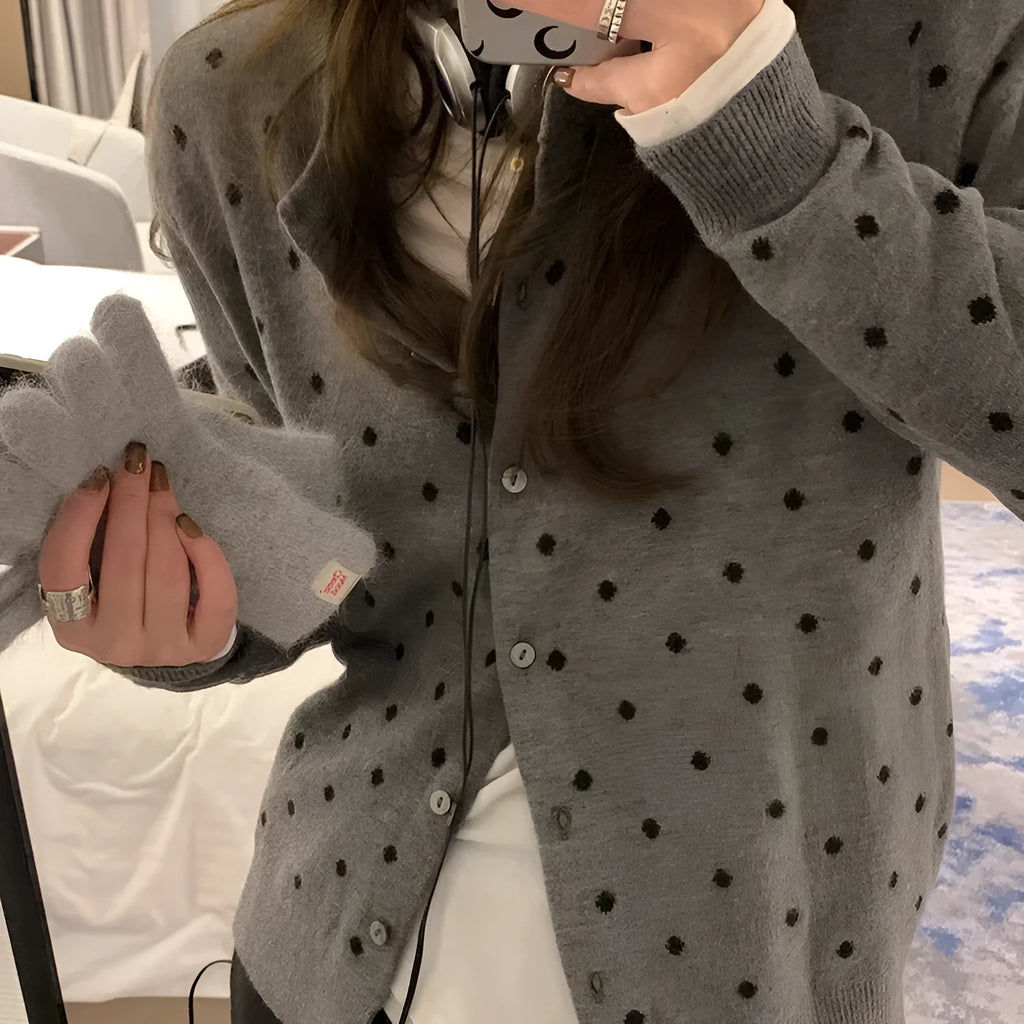 Women's grey dot knitted cardigan with long sleeves and crocheted flower detail.