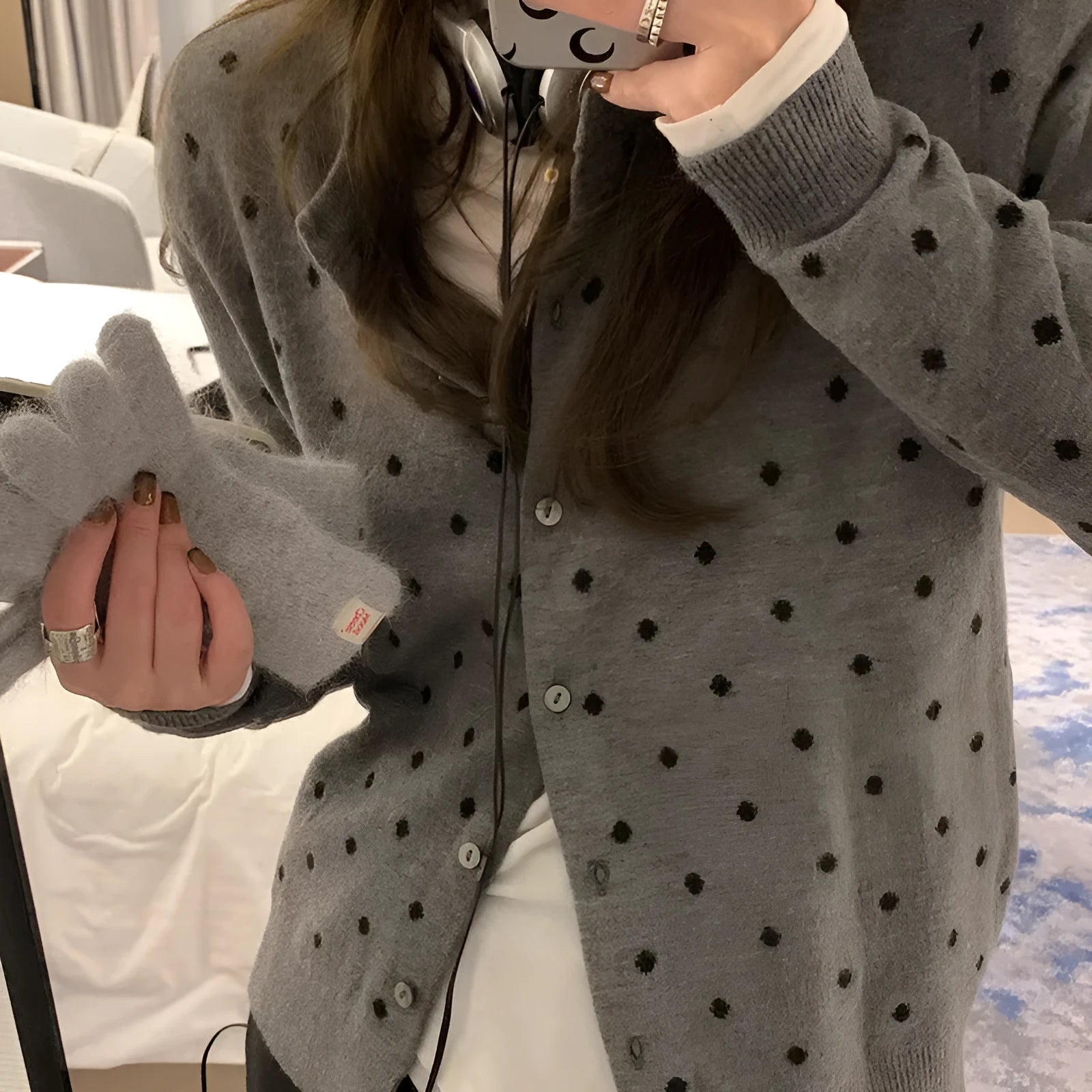 Women's grey dot knitted cardigan with long sleeves and crocheted flower detail.