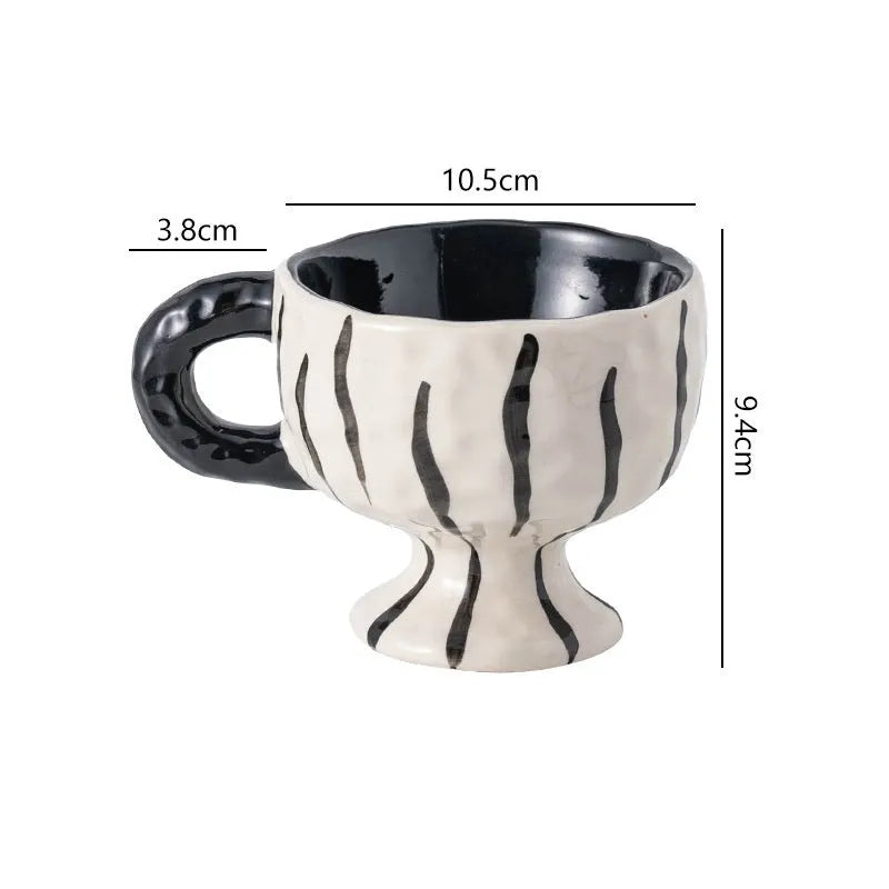 A handmade, irregularly shaped ceramic mug in a solid colour, shown on a table.