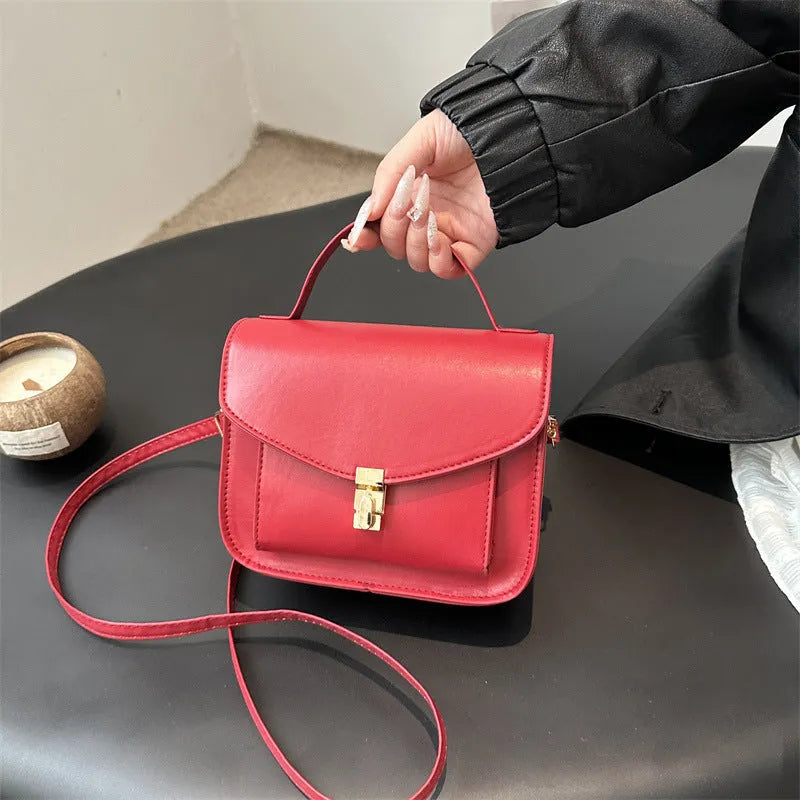 Horizontal square black PU messenger bag with a front sandwich pocket and visible sewing lines.
