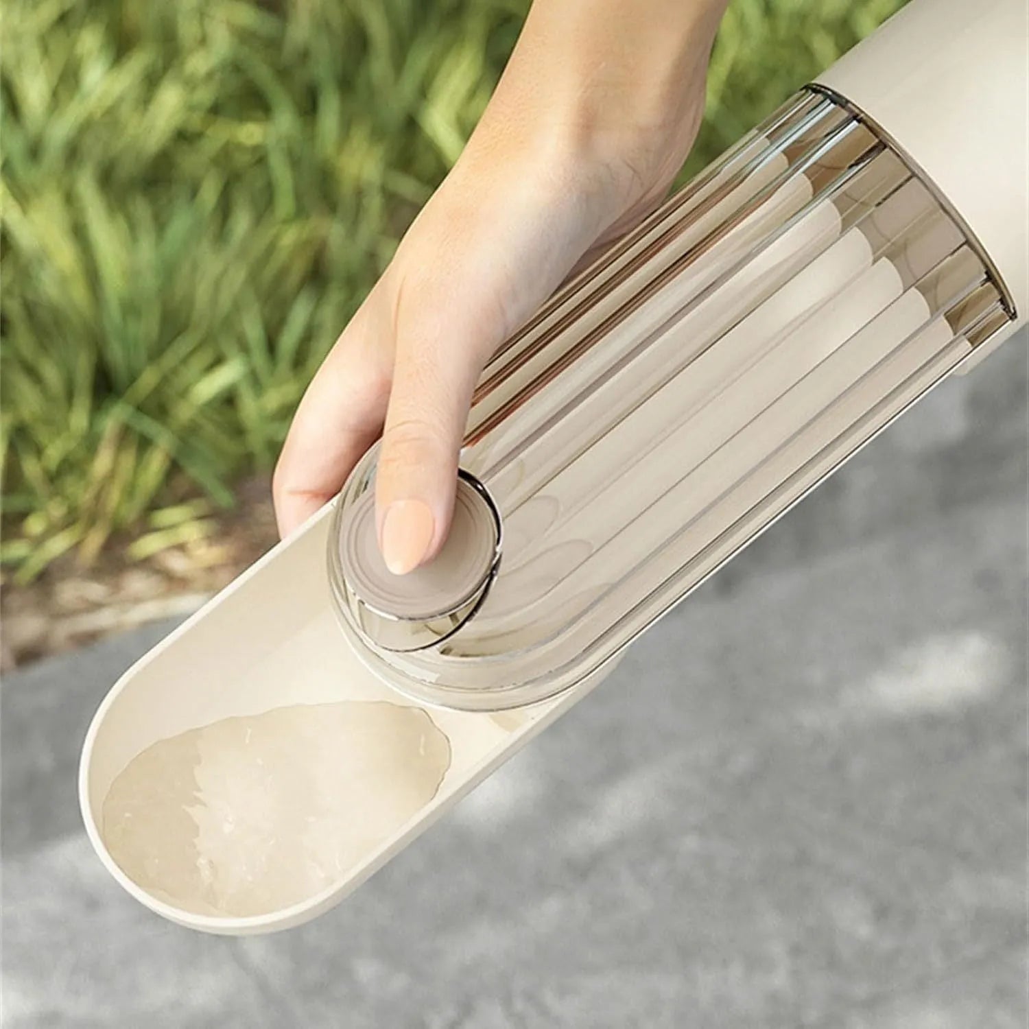 Beige foldable dog water bottle with integrated food container for outdoor walks.