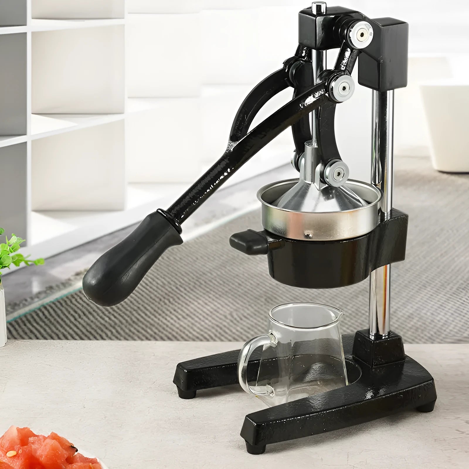 Upgraded black manual cast iron juicer with stainless steel funnel, 40 cm tall on a kitchen counter.