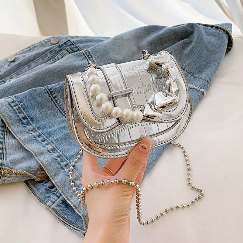 Silver square women's crossbody bag with single shoulder strap showing internal phone pocket