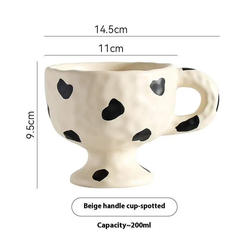 A handmade, irregularly shaped ceramic mug in a solid colour, shown on a table.