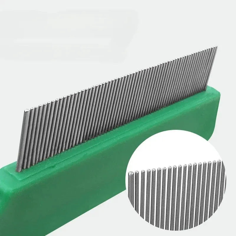 Green plastic handle stainless steel pet flea comb for dogs and cats on a plain background.
