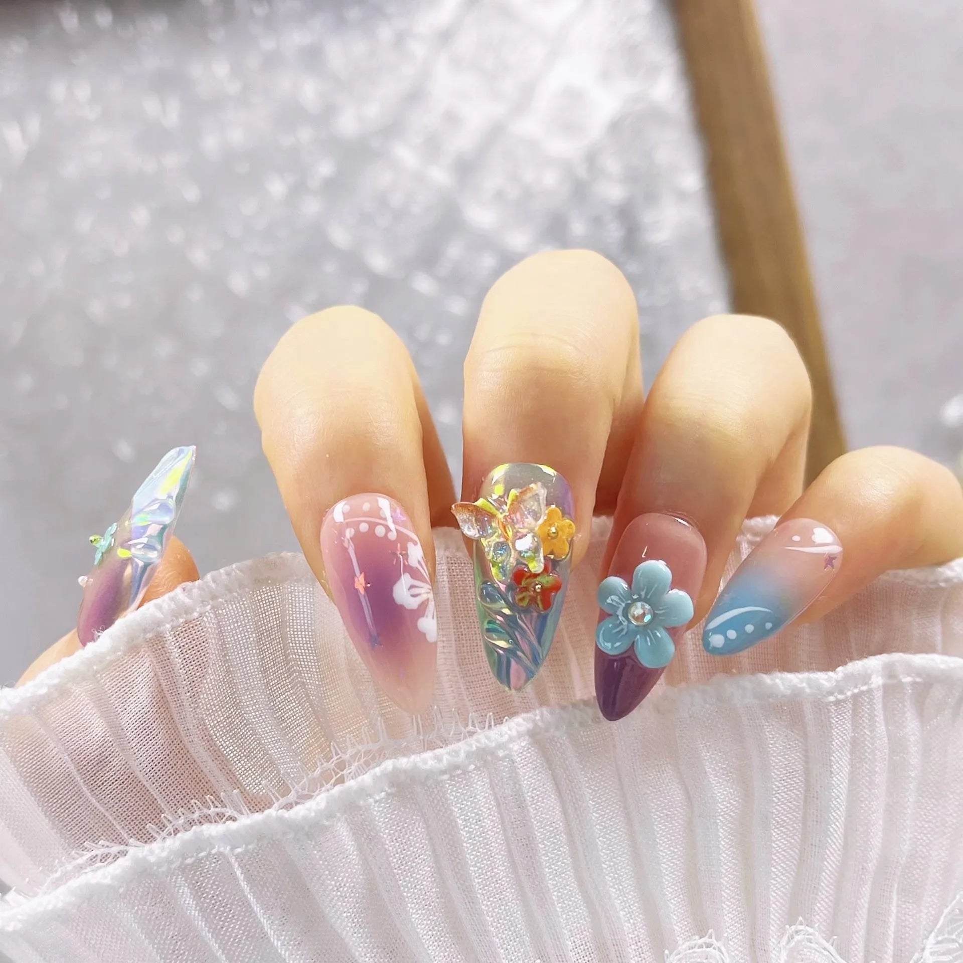 Handmade acrylic press-on nails with colourful 3D embossed flower and butterfly sculptures in almond shape.