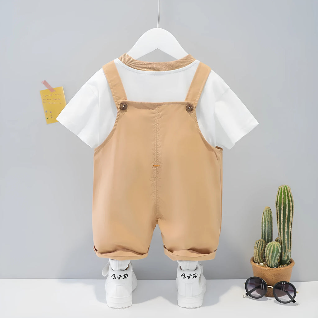 Baby wearing yellow cotton short-sleeved overalls with a cartoon print and openable straps.