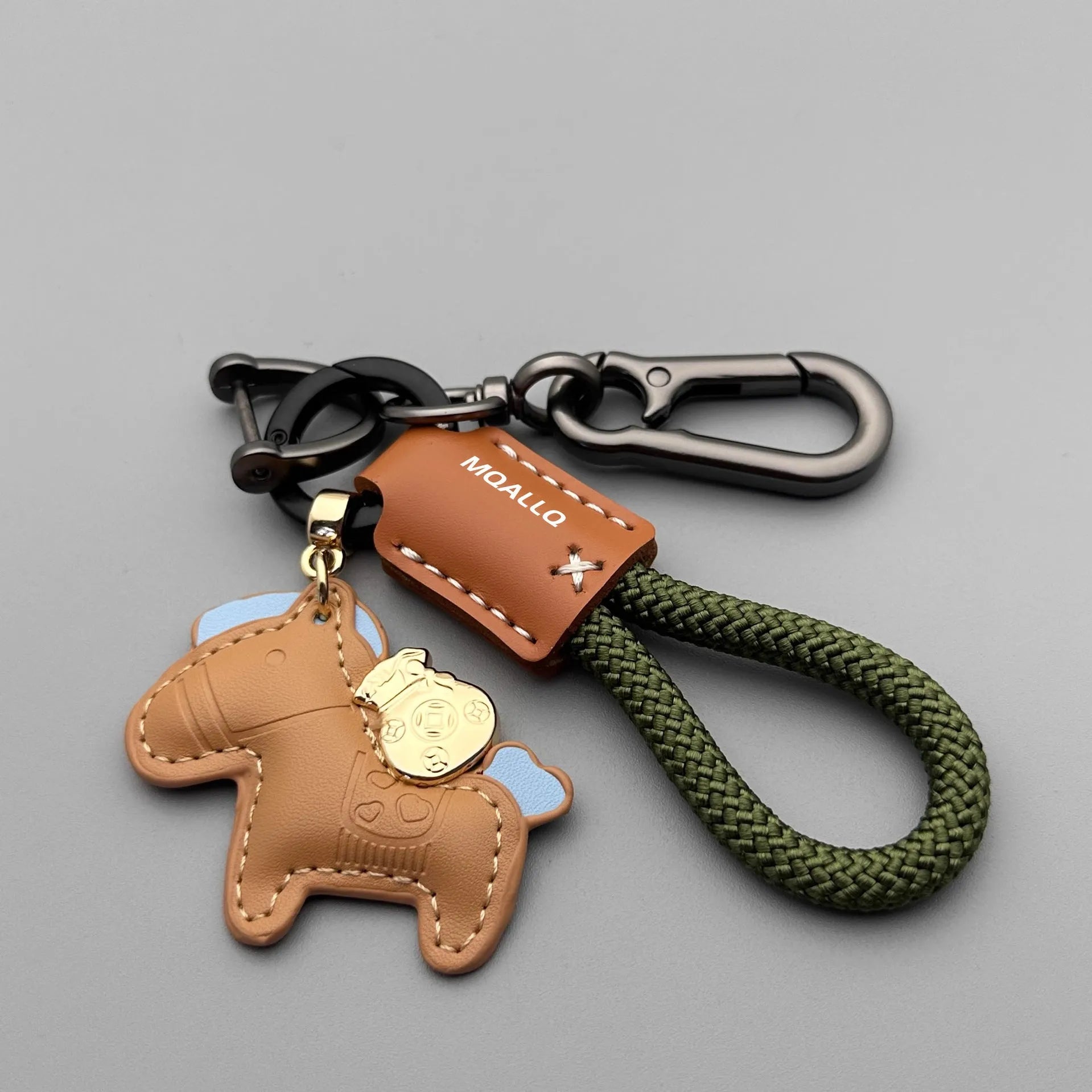 Handmade brown cowhide leather key ring with a gold pony belt buckle charm and a green flanelle rope loop.