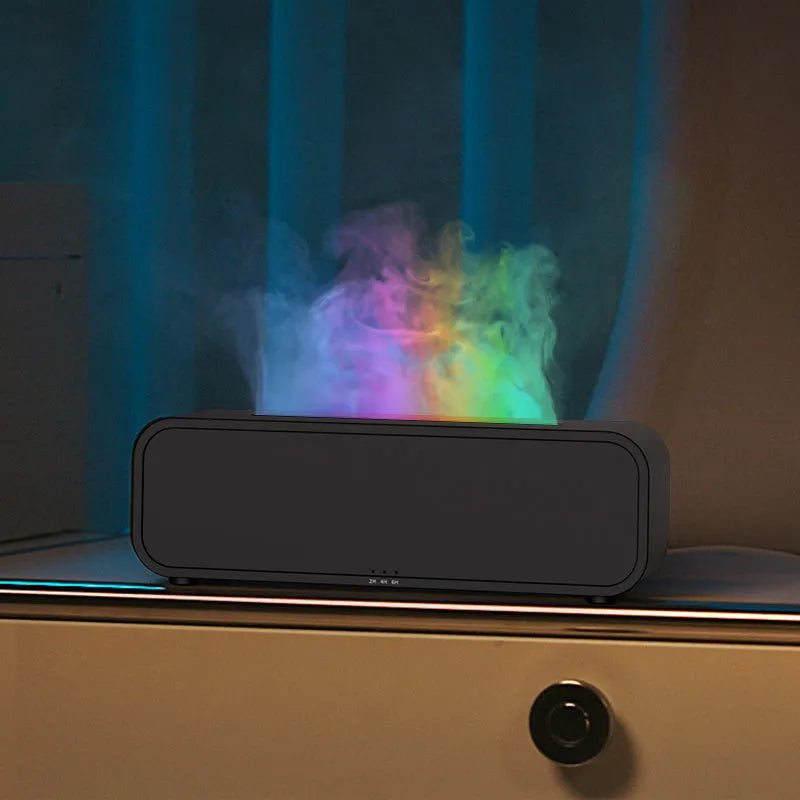 Black and white aroma diffuser with flame animation and coloured LED lights on a wooden table.