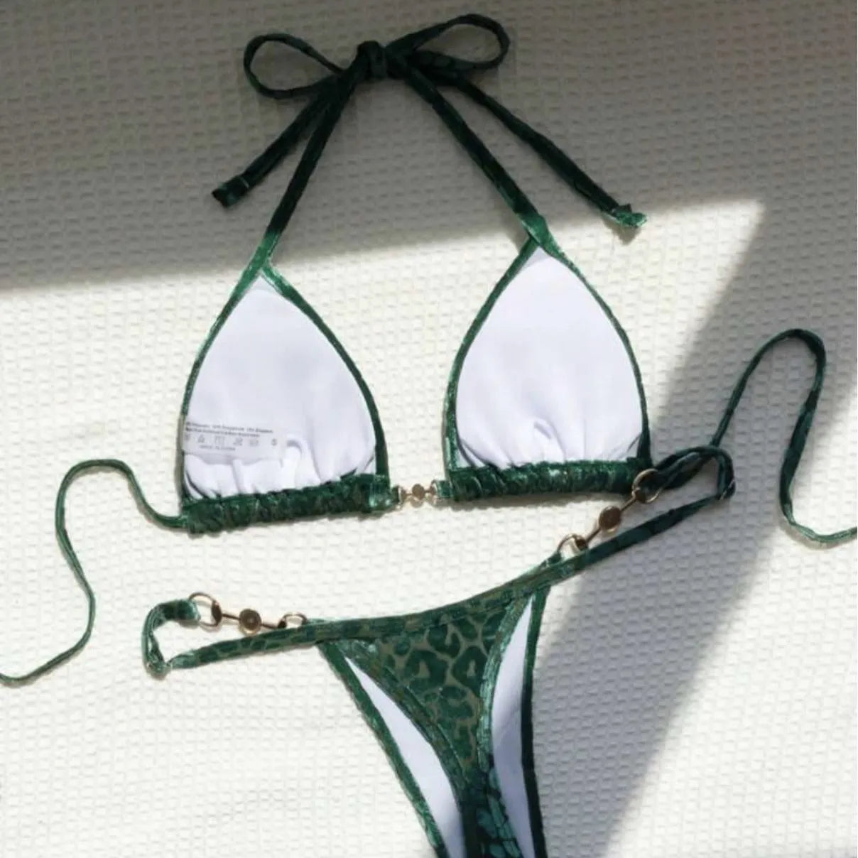 Blue and green leopard print women's bikini set on a mannequin, showing T-shaped design.
