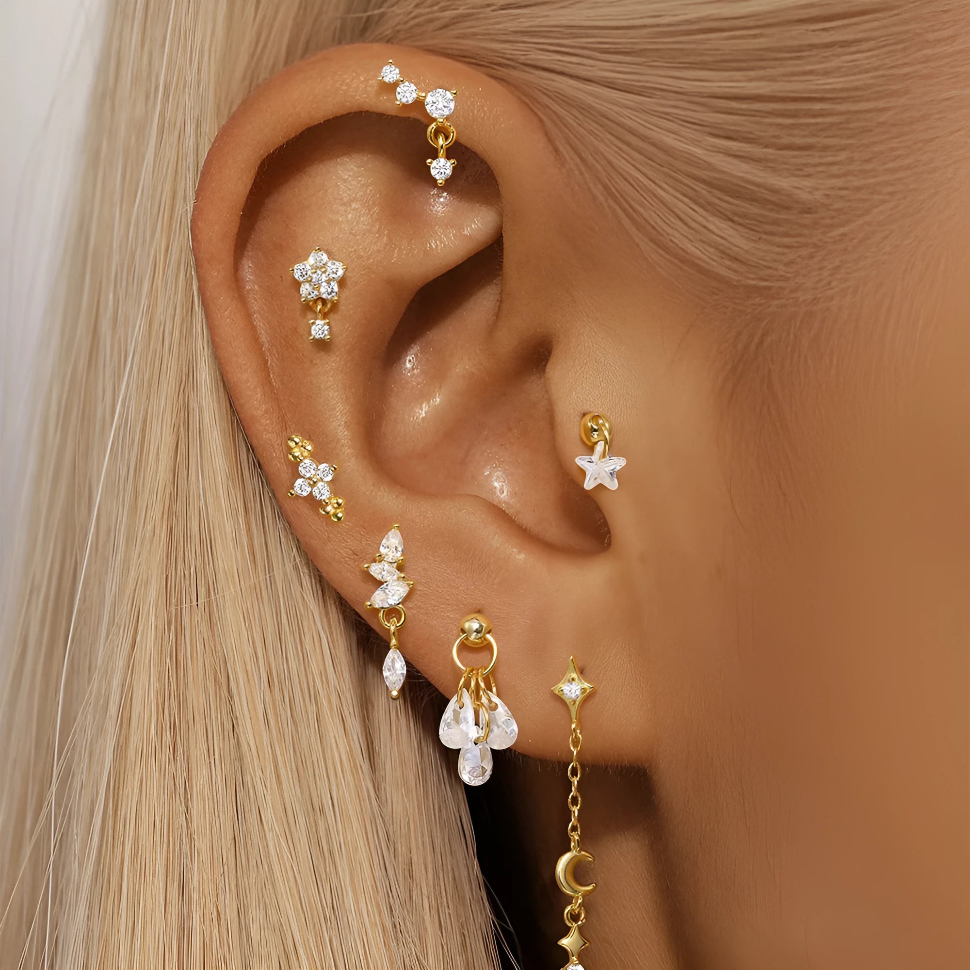 S925 sterling silver geometric moon and embedded star piercing earrings on a gold-colour background.