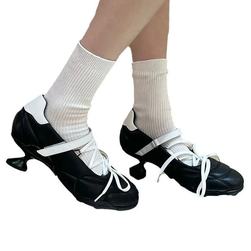 Women's silver lace-up sports shoes with a bow detail and a mid-height heel on a white background.