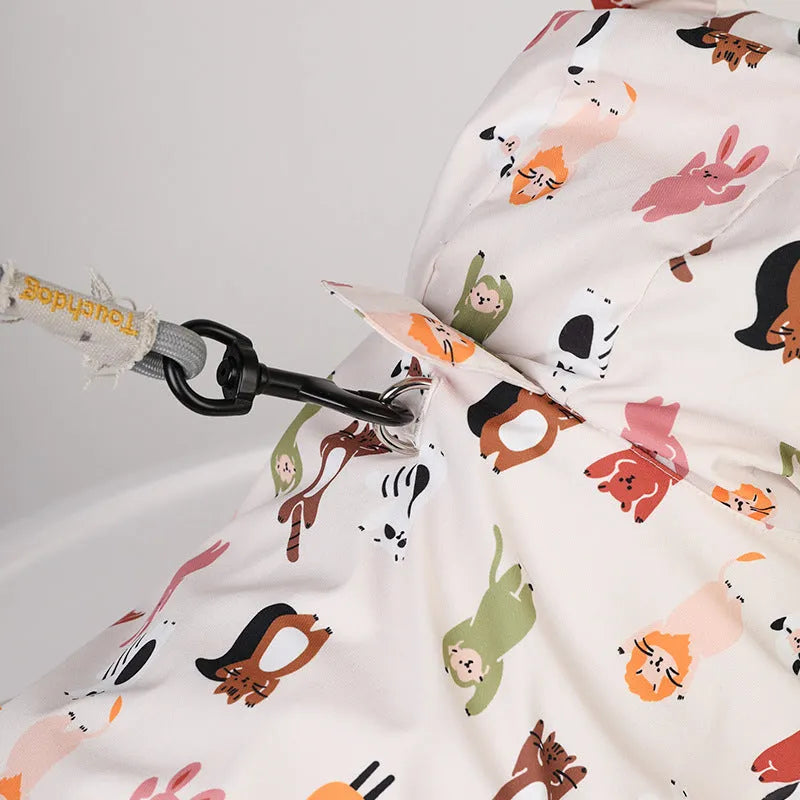 Beige dog raincoat with cartoon cat head pattern, showing waterproof PU material