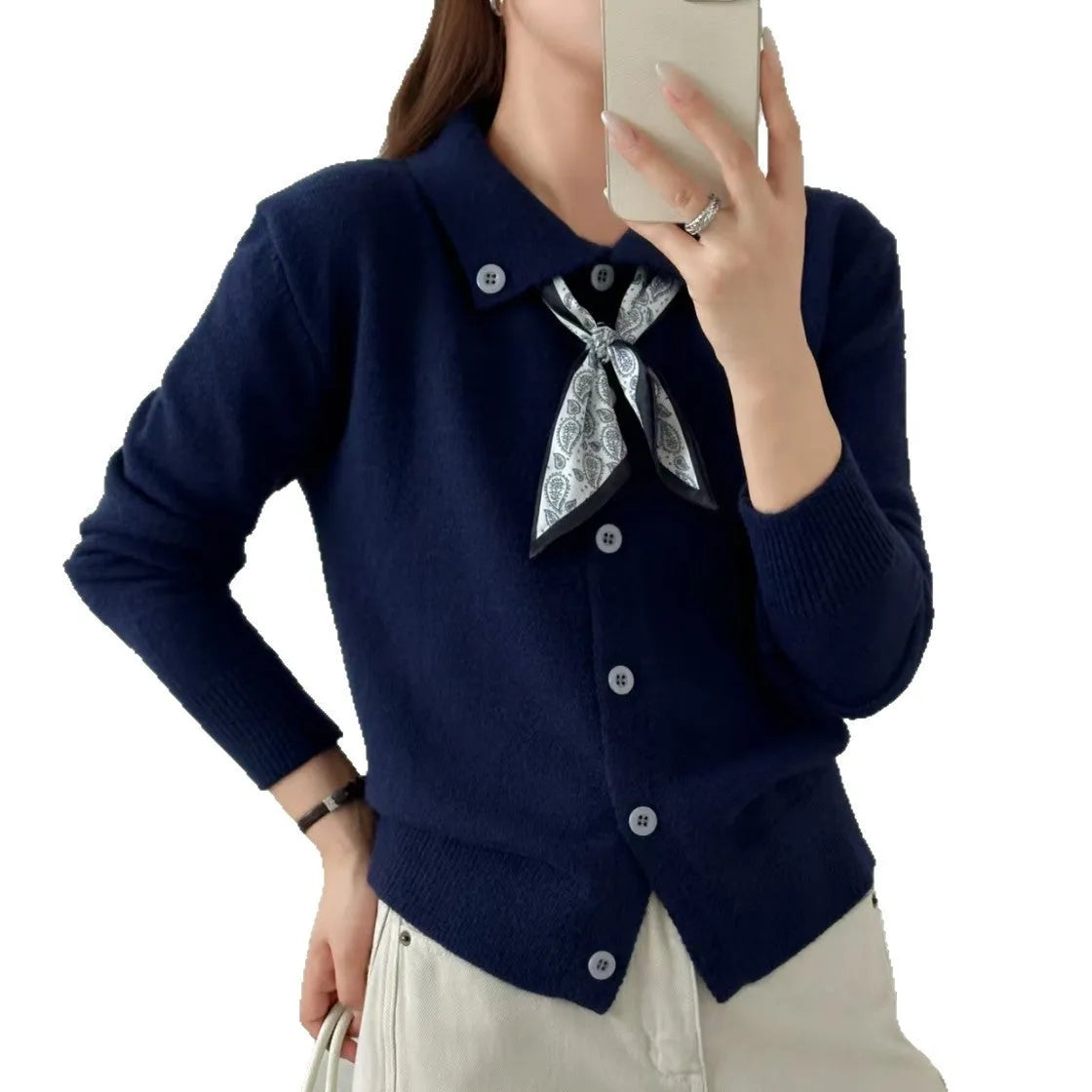 Beige acrylic cardigan with lapel scarf collar and splicing detail on a hanger.