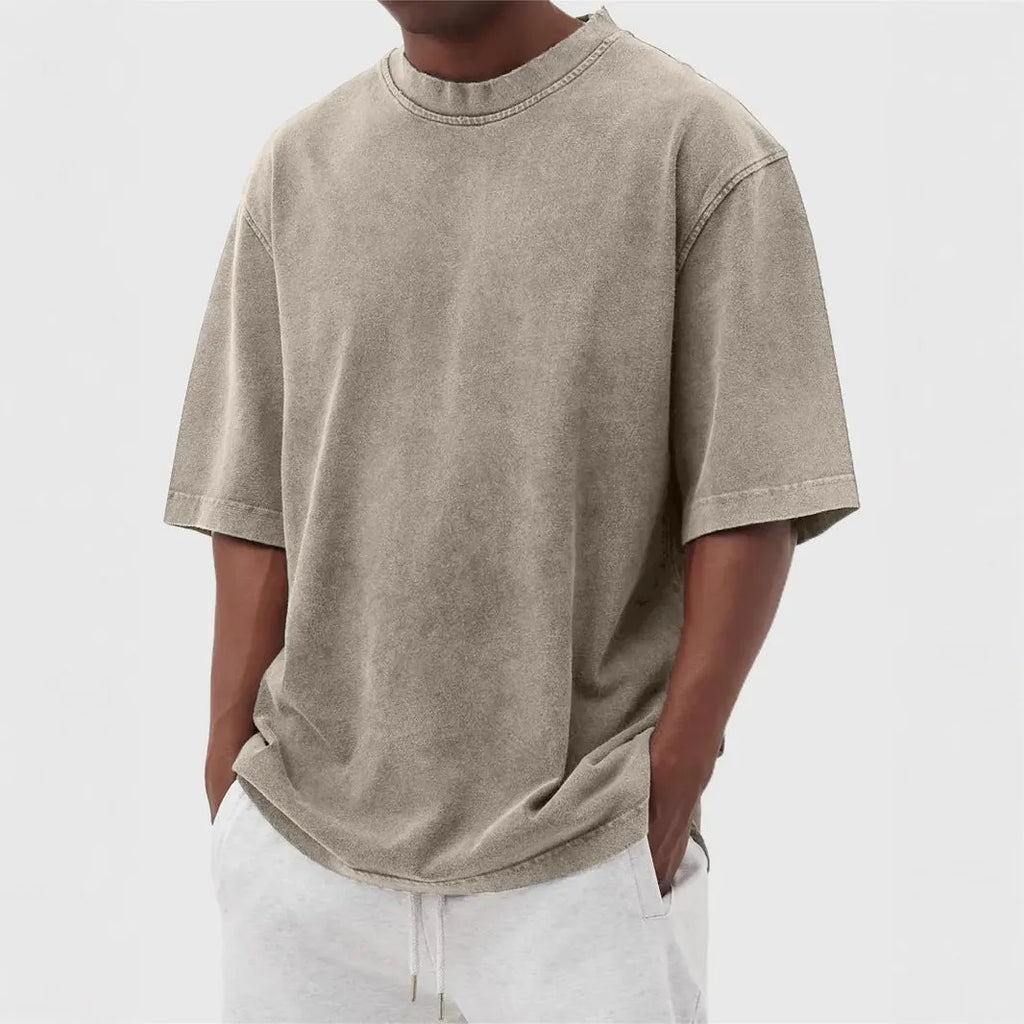 Man wearing a loose-fit distressed pullover T-shirt in a solid colour, showcasing the casual style and half-sleeve design.