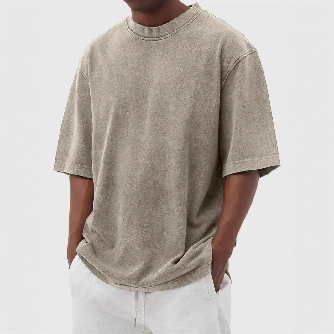 Man wearing a loose-fit distressed pullover T-shirt in a solid colour, showcasing the casual style and half-sleeve design.