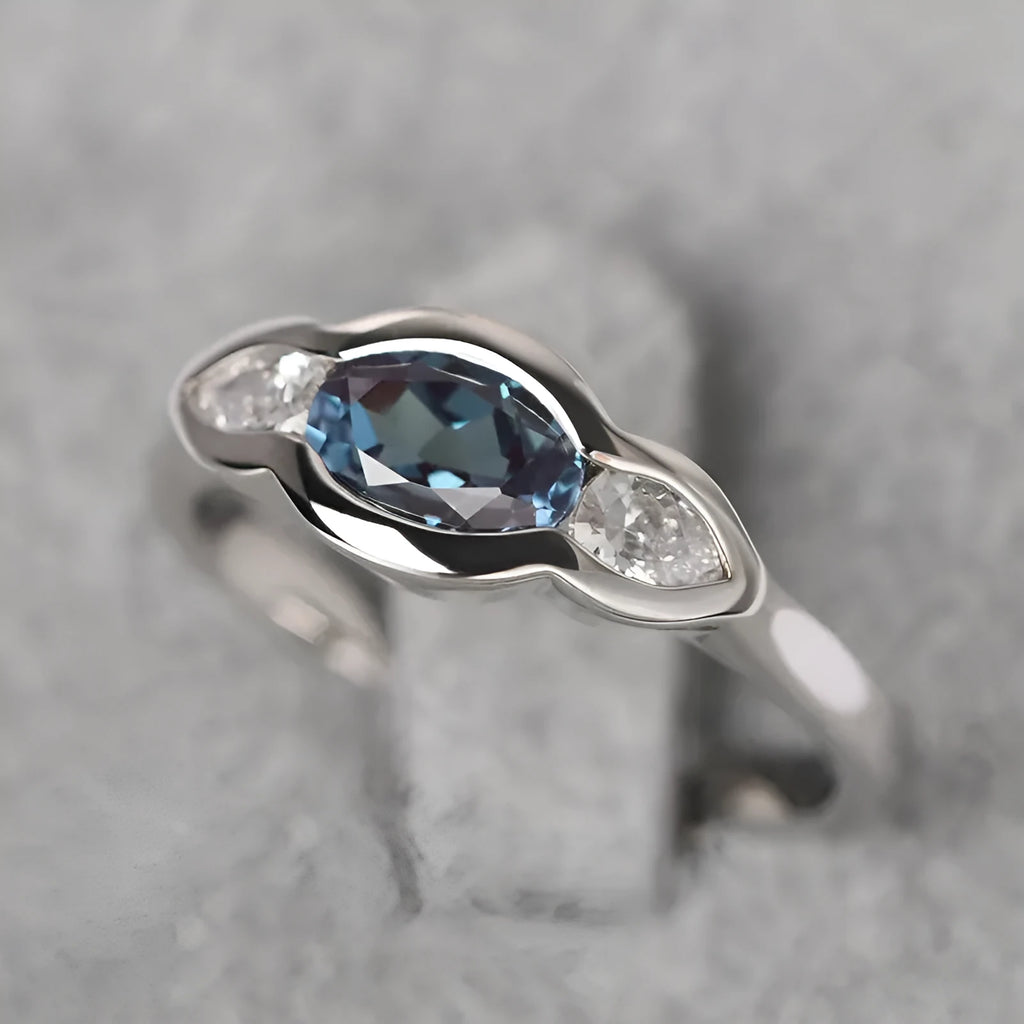 Geometric ellipse-shaped women's ring with inlaid zircon stones in a white gold finish.
