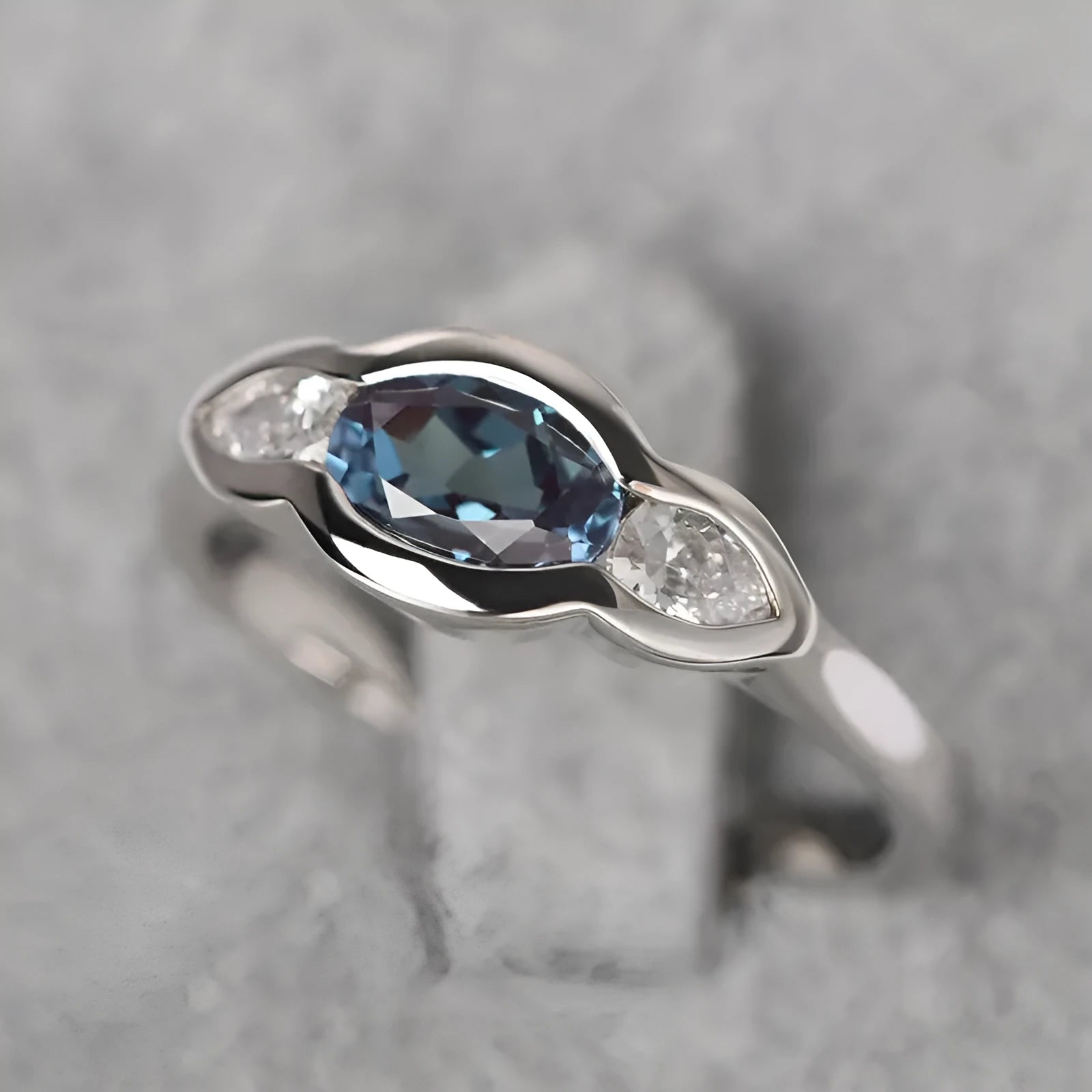 Geometric ellipse-shaped women's ring with inlaid zircon stones in a white gold finish.