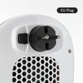 White portable ceramic electric fan heater with remote control on a table.