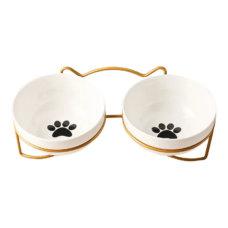 White ceramic cat food bowl with cat paw print design on black iron frame stand