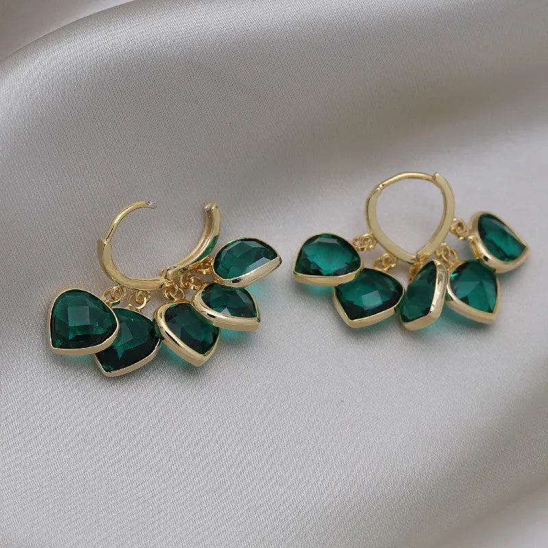Pair of green heart-shaped glass pendant ear clip earrings with alloy and artificial gemstone details.