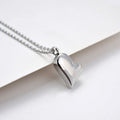 Silver stainless steel necklace with a curved peach heart pendant on an adjustable chain.