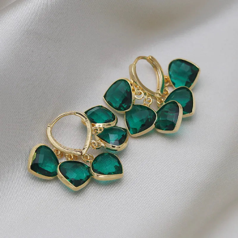 Pair of green heart-shaped glass pendant ear clip earrings with alloy and artificial gemstone details.