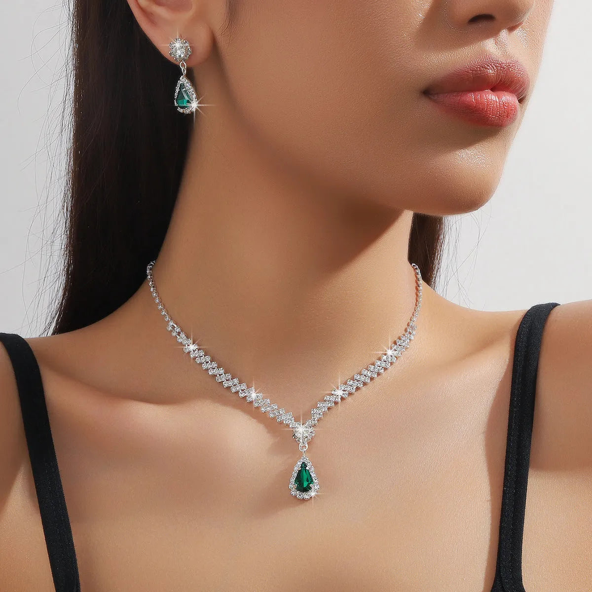 Women's rhinestone water drop necklace and earrings set on a claw chain in blue colour.