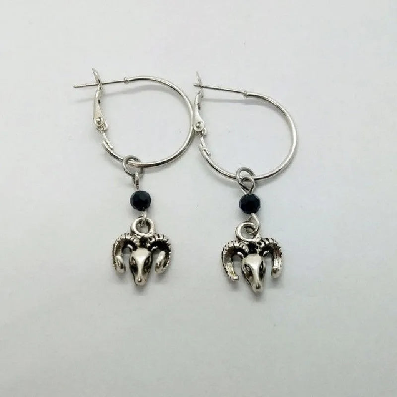 Silver Tibetan antelope round ring drop dangle earrings on a white background.
