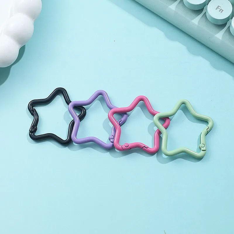 Zinc alloy five-pointed star keychain in assorted macaron colours including pink, blue, and purple