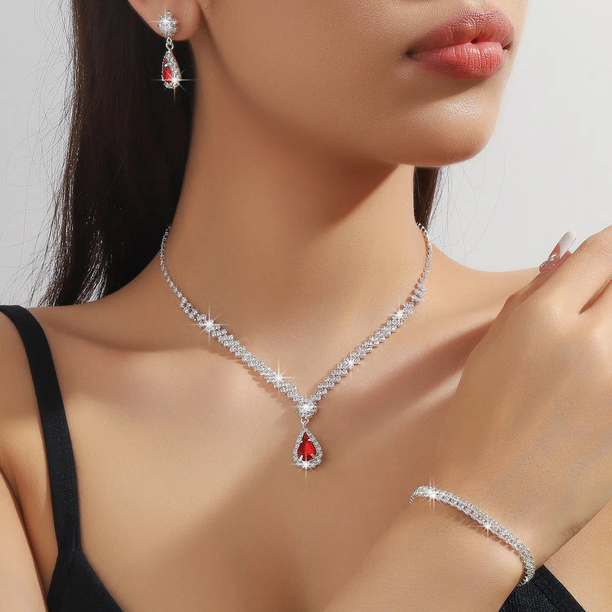 Women's rhinestone water drop necklace and earrings set on a claw chain in blue colour.