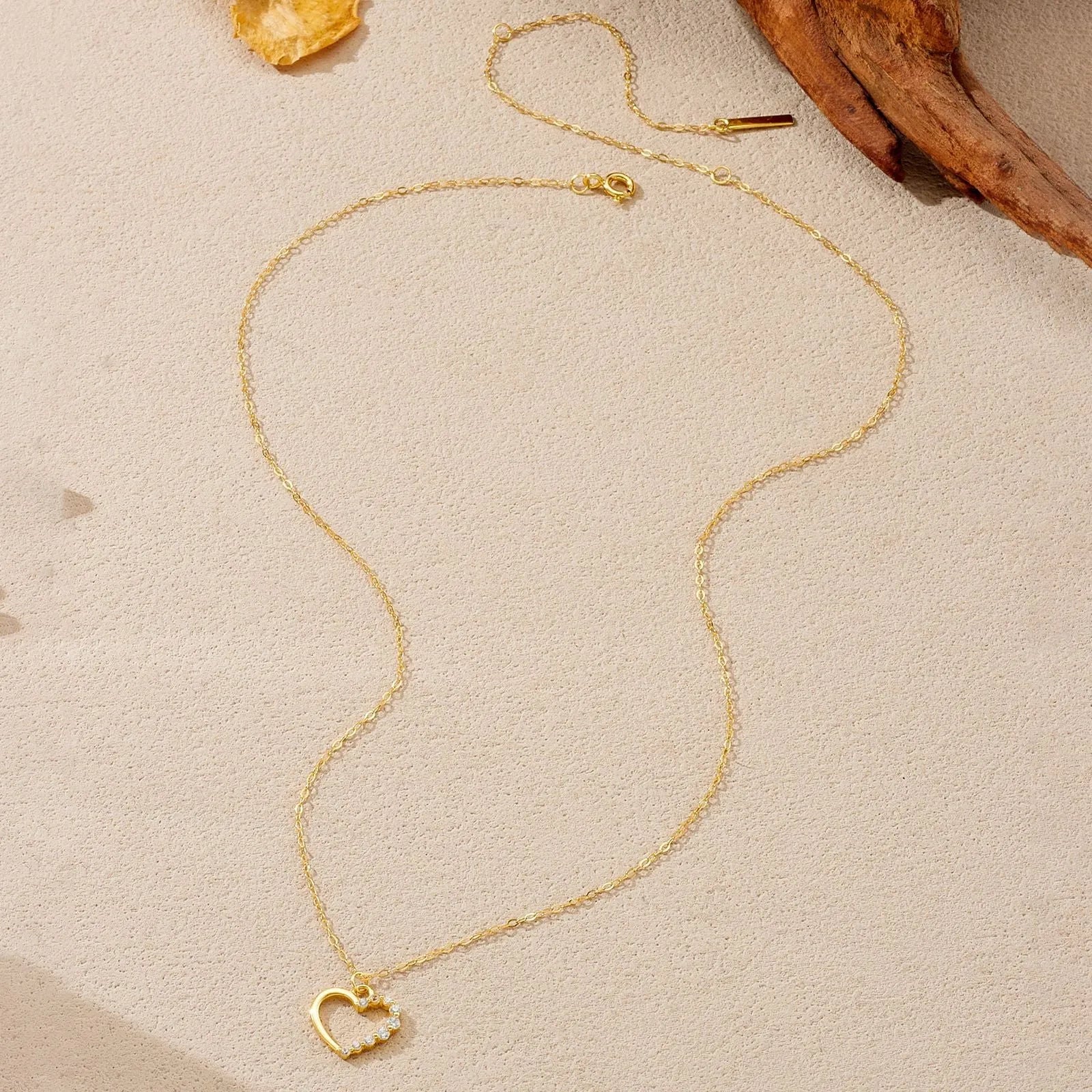 Sterling silver hollow heart pendant necklace on a classic chain, available in white gold or 18K gold plating.