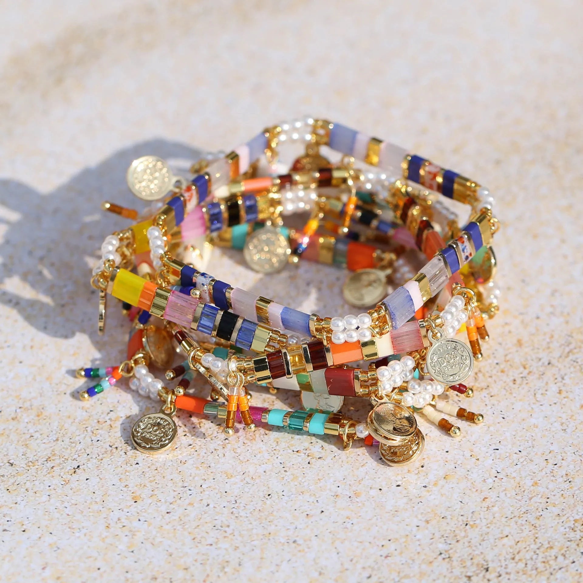 Handcrafted women's bracelet featuring imitation pearls and coloured glass beads on a wrist.