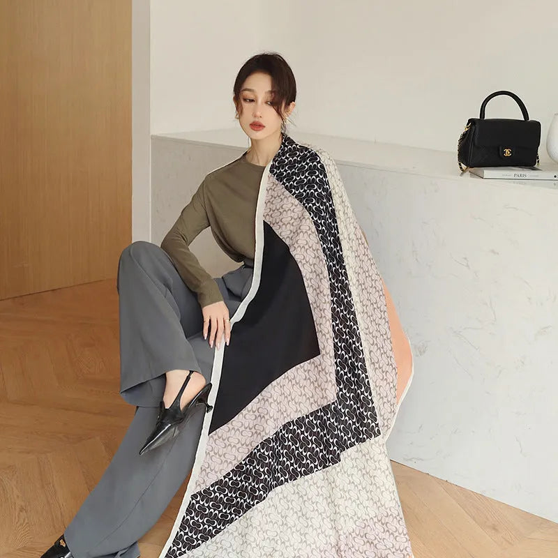 A woman wearing a printed polyester shawl measuring 180cm by 90cm.