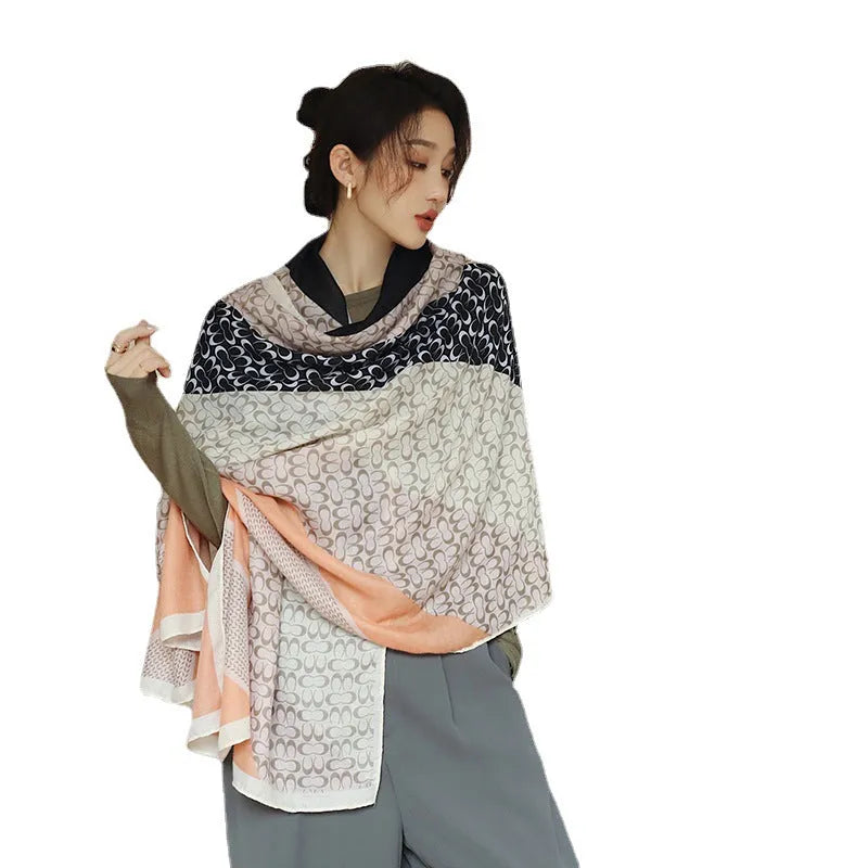 A woman wearing a printed polyester shawl measuring 180cm by 90cm.
