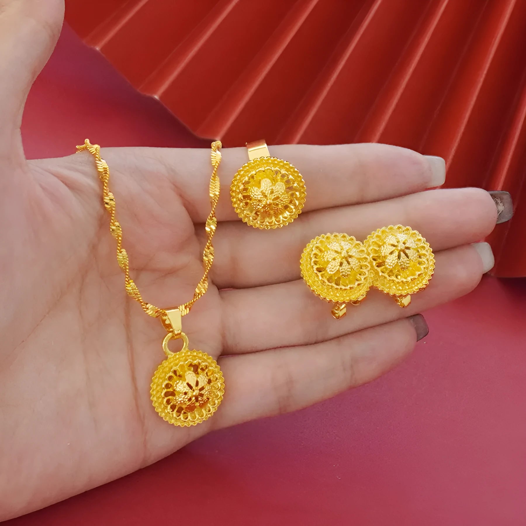 Gold-plated three-piece jewellery set with floral designs including necklace, earrings, and ring