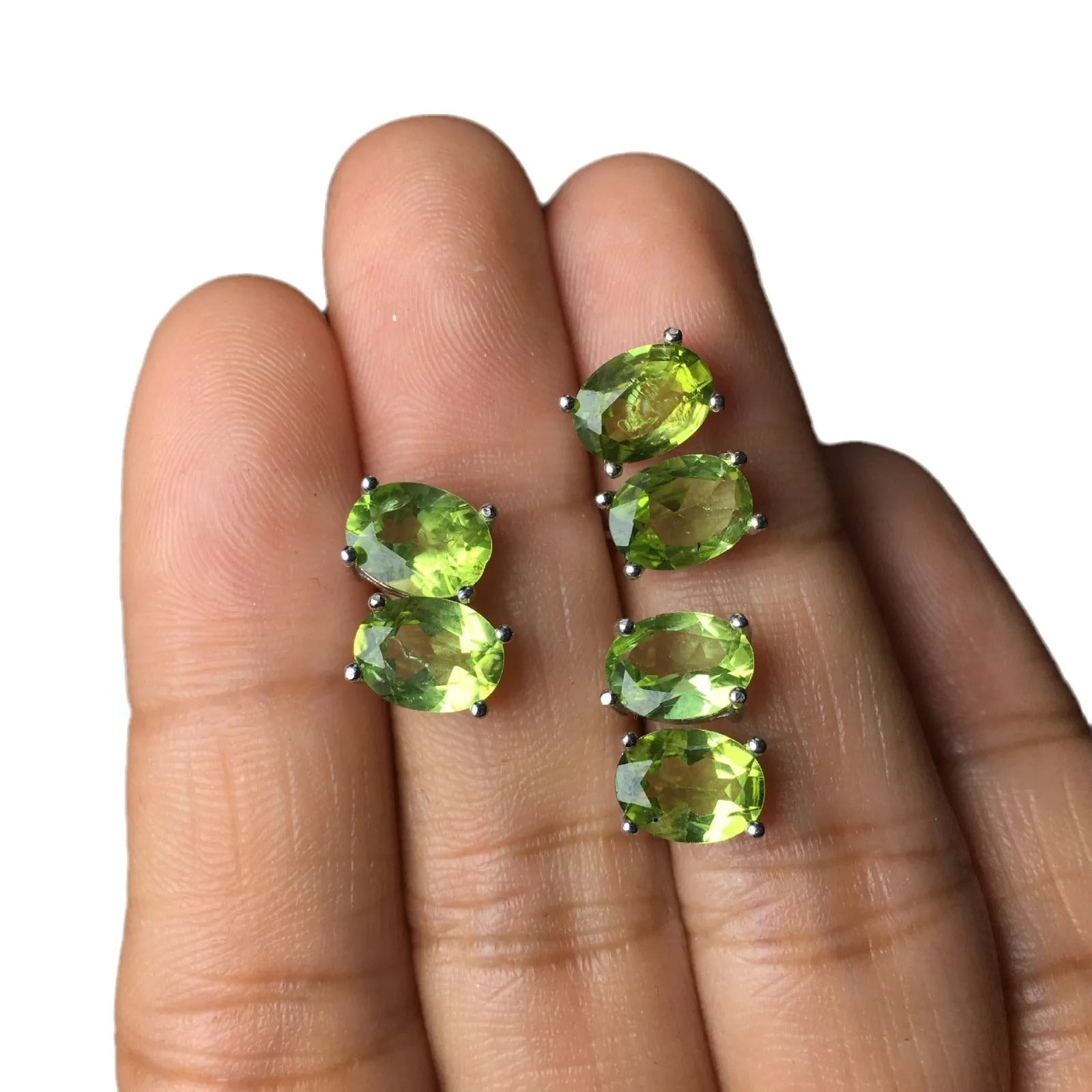 Natural grass green olivine faceted stud earrings in S925 silver settings on a white background.