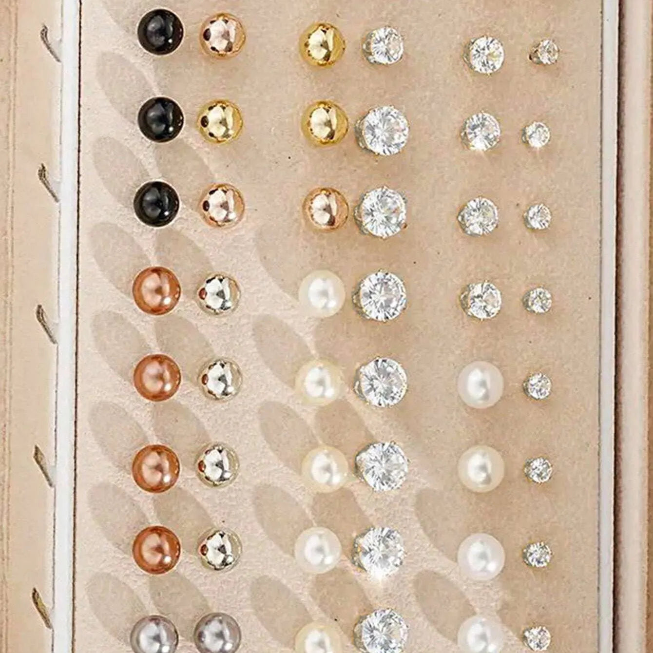 108 gold and yellow alloy stud earrings with geometric shapes and round pearl details on a plain surface.